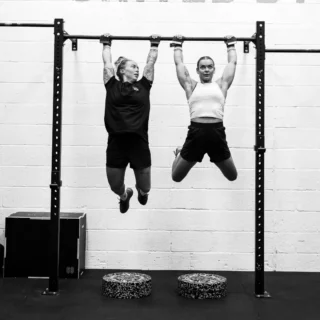 Client using pull-up bars for strength training at TEAM NTS gym
